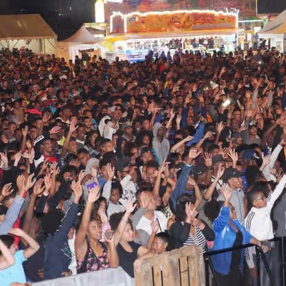Foule immense les mains levées lors d'un événement public de nuit à La Réunion